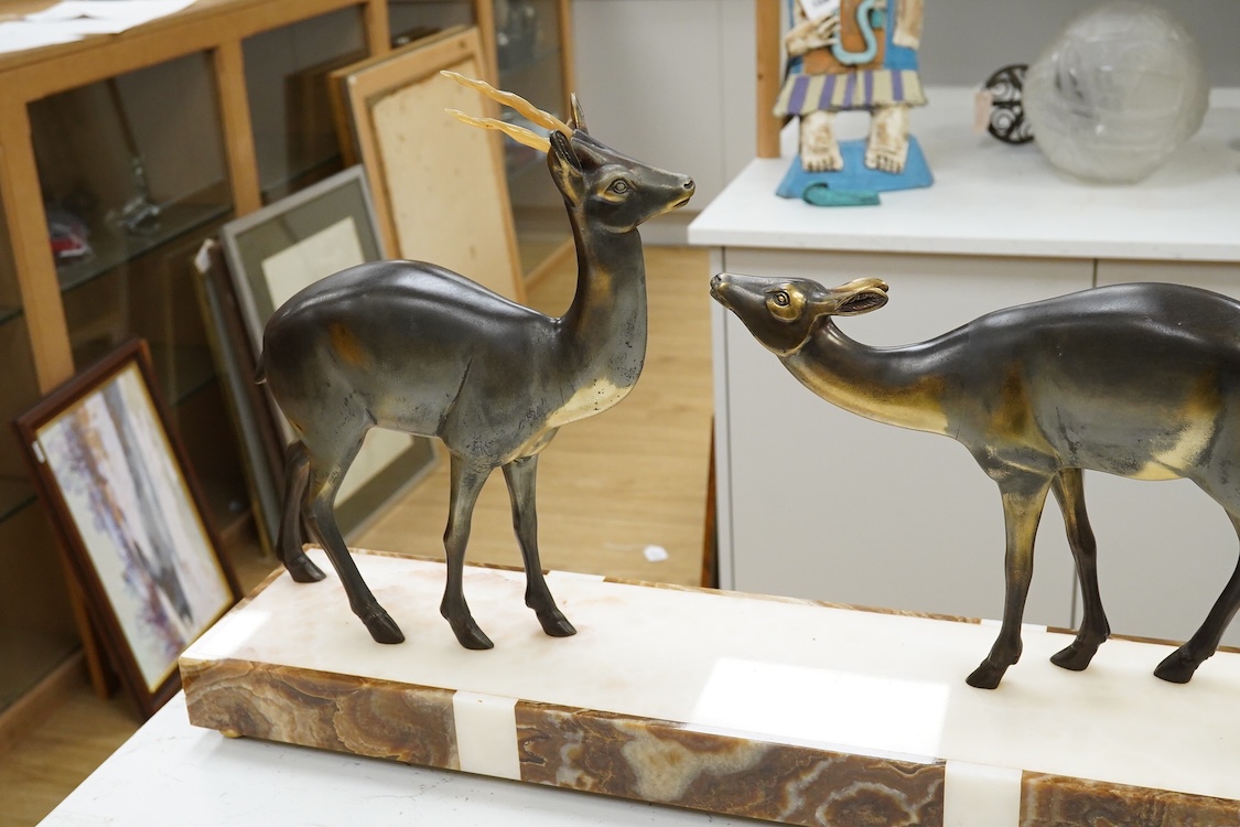An Art Deco spelter and marble stag and deer group, 70cm wide